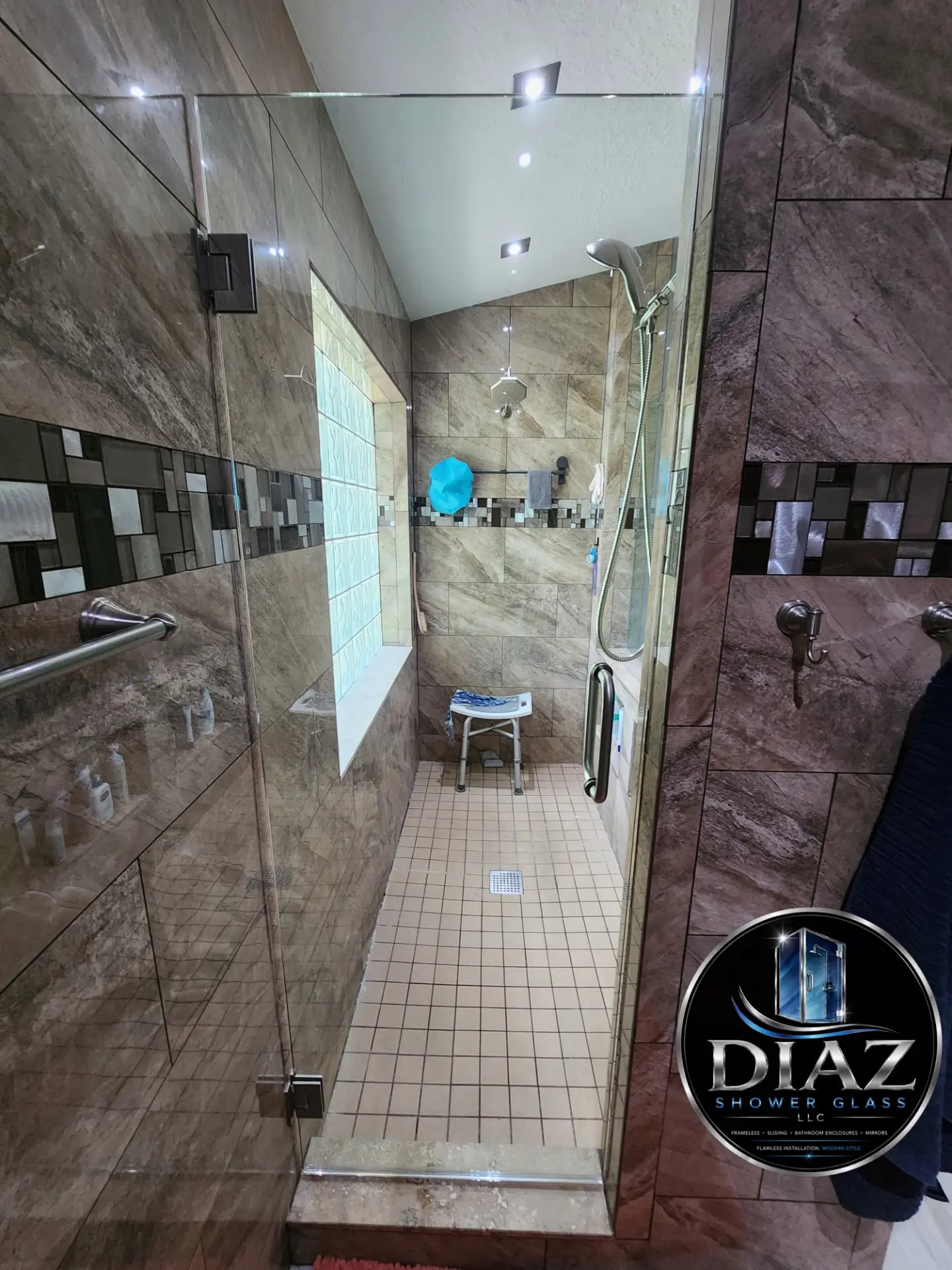 Walk-in frameless glass shower enclosure with stone tile